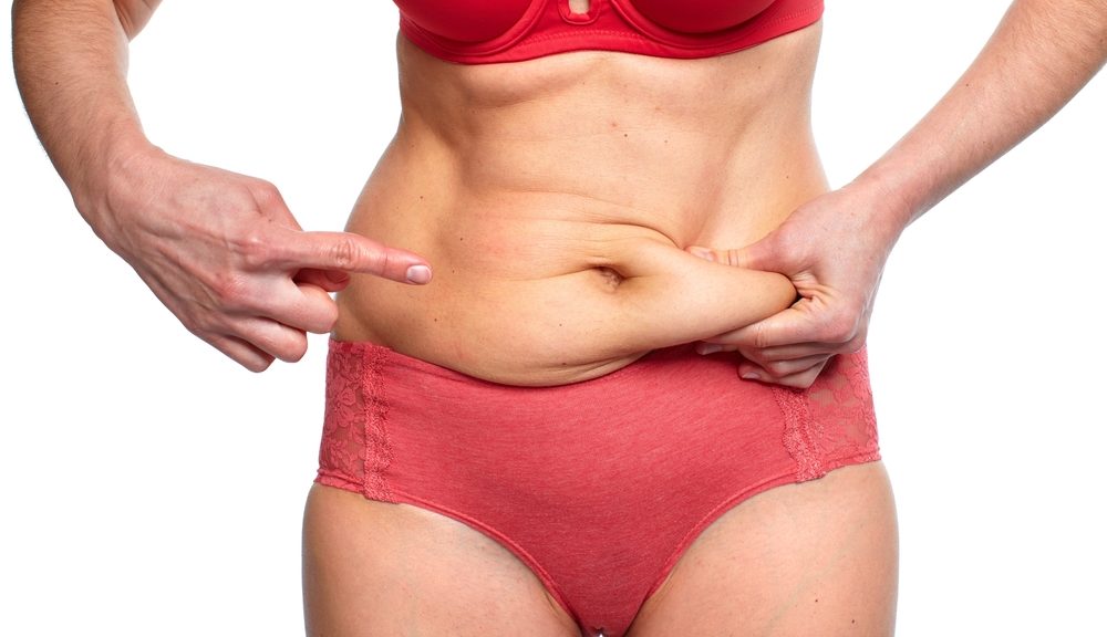 woman pinching loose abdomen