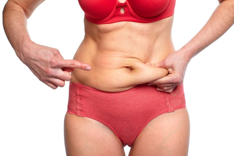 woman pinching loose abdomen