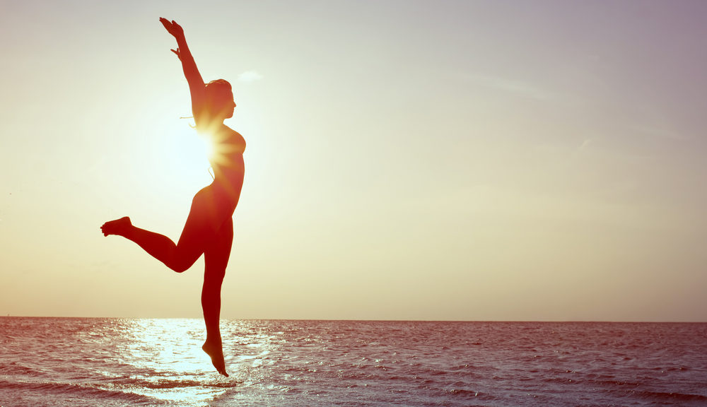 Woman Jumping for Joy on the Beach